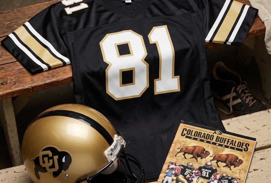 AI-generated black jersey 81 on a wooden table with a black "Buffalo" emblem on a gold helmet and period example of a program