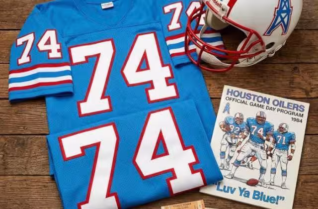Gemini AI generated image of a 1980s-era blue American football jersey 74, without a name on it, and a matching period-correct helmet, the program cover appropriate to the era and team.