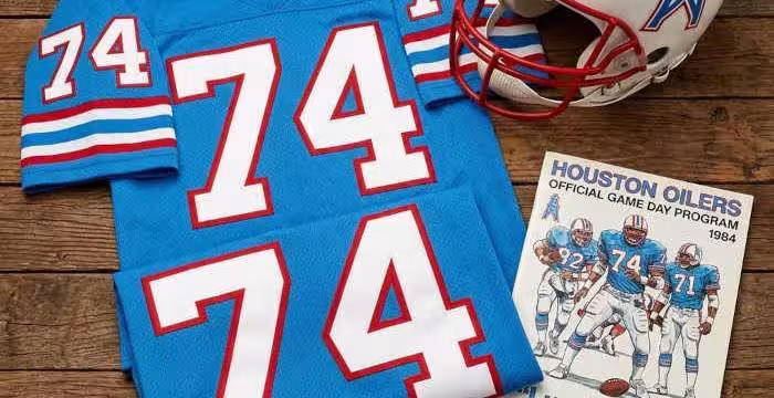 Gemini AI generated image of a 1980s-era blue American football jersey 74, without a name on it, and a matching period-correct helmet, the program cover appropriate to the era and team.