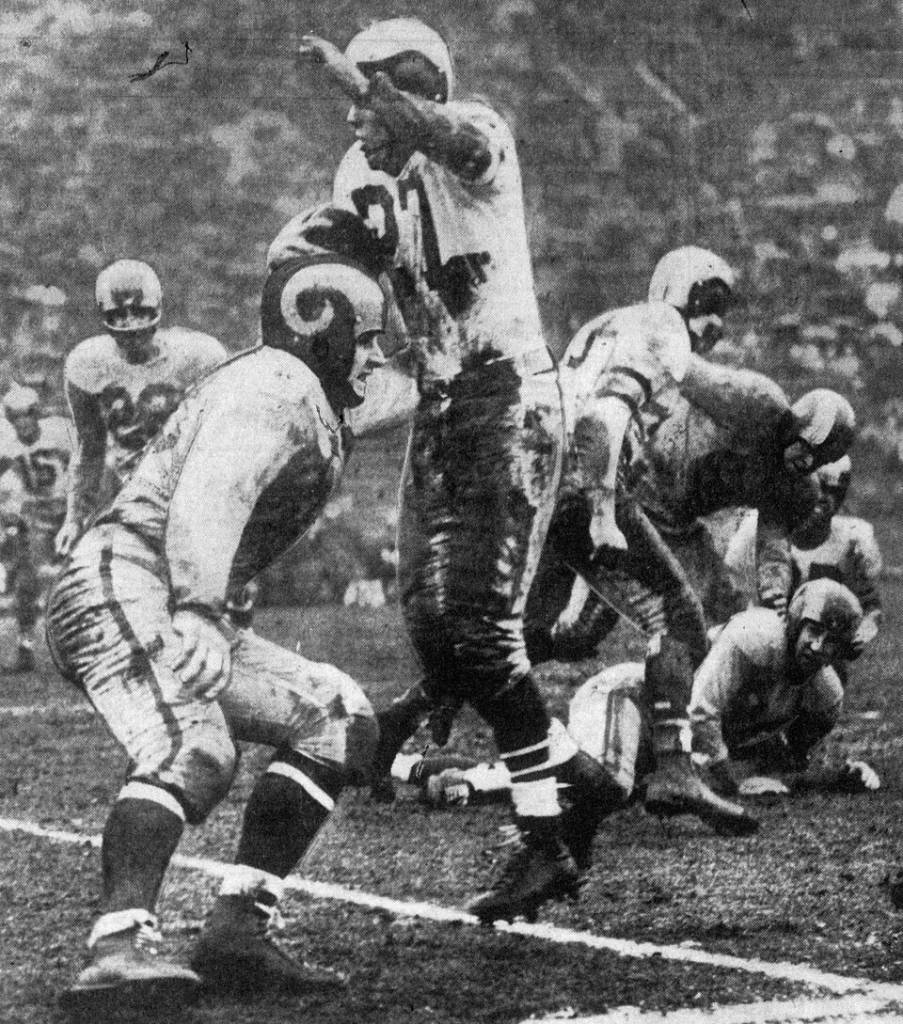 Philadelphia Eagles halfback Clyde Scott (center, number 27) runs into Los Angeles Rams defender Dick Huffman (left foreground) during the NFL Championship Game on December 18, 1949 at Los Angeles Memorial Coliseum in Los Angeles, California.