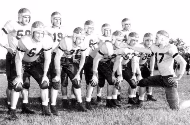 Black and white posed team huddle of Florida State University football squad: Tallahassee, Florida Date: 1947