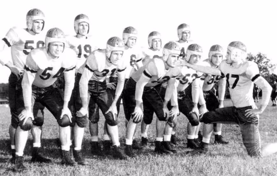 Black and white posed team huddle of Florida State University football squad: Tallahassee, Florida Date: 1947