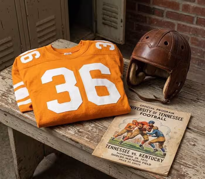 Gemini AI-created image of a 1935-era University of Tennessee American football jersey 36, without a name on it, and a matching period-correct helmet, the program cover appropriate to the era and team.