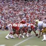 A view from the field in a packed Ohio Stadium as the Ohio State Buckeyes play the Colorado Buffaloes. The Buckeyes won the football game 13-10, in front of a crowd of 88,404 spectators. This photograph features the Buckeye offense on the field led by Jim Karsatos, #16, at quarterback. Sept 20, 1986.