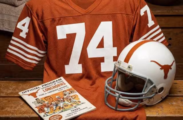 Gemini AI-created image of a 1970-era Texas American football jersey 74, without a name on it, and a matching period-correct helmet, the program cover appropriate to the era and team.