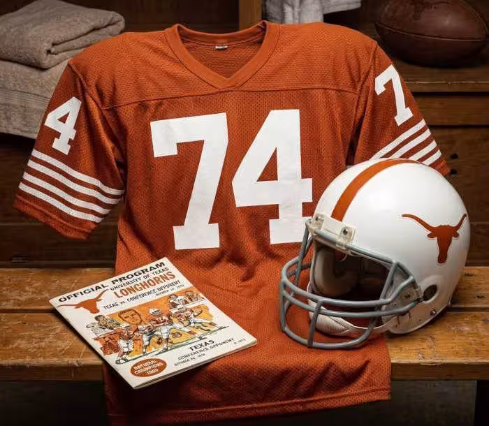 Gemini AI-created image of a 1970-era Texas American football jersey 74, without a name on it, and a matching period-correct helmet, the program cover appropriate to the era and team.