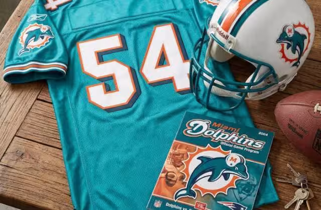 Gemini AI-created image of a 2004-era Miami NFL American football jersey 54, without a name on it, and a matching period-correct helmet, the program cover appropriate to the era and team.