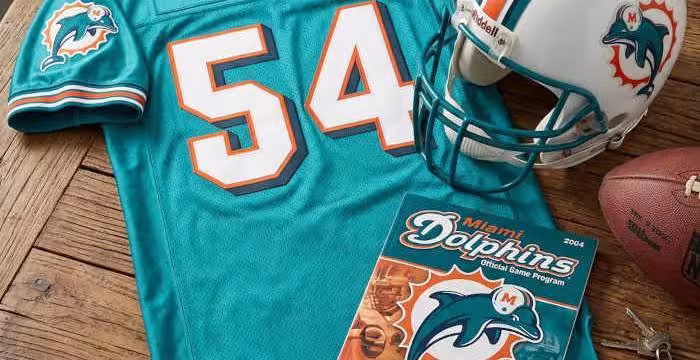 Gemini AI-created image of a 2004-era Miami NFL American football jersey 54, without a name on it, and a matching period-correct helmet, the program cover appropriate to the era and team.