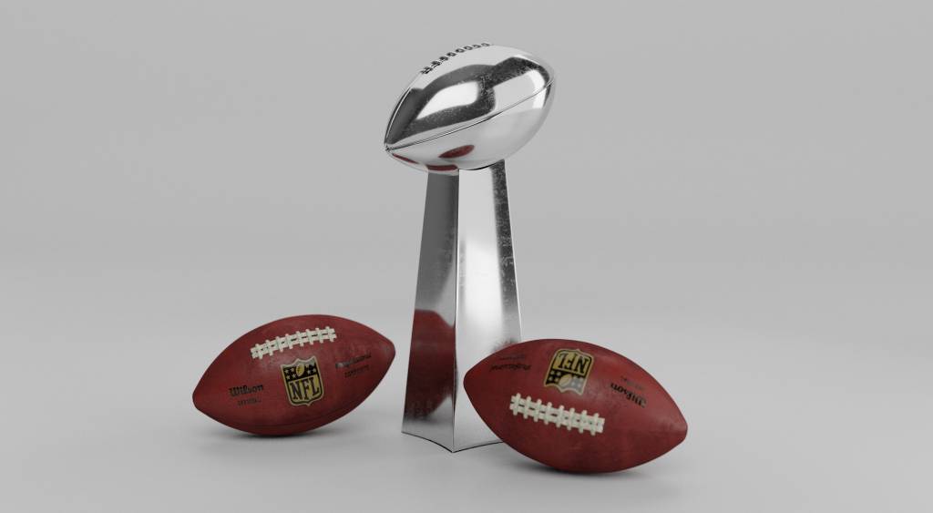Full color Image of the Lombardi trophy with two NFL Wilson footballs sitting on either side of it.
