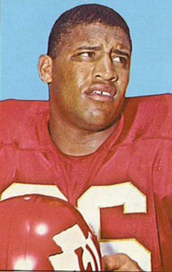 Full color trading card of 1965 Topps card of Buchanan for Kansas City Chiefs wearing the all red number 86 with helmet in hand.