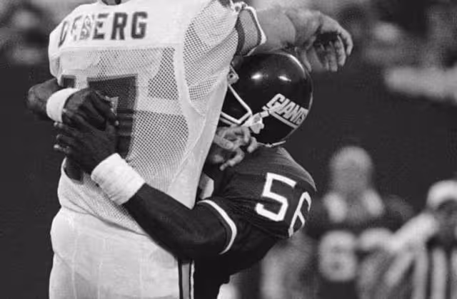 Black and white game action image of Taylor tackles Steve DeBerg on September 23, 1984.