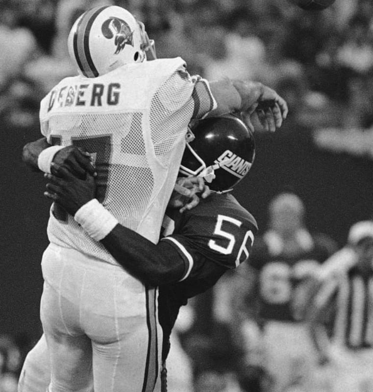Black and white game action image of Taylor tackles Steve DeBerg on September 23, 1984.