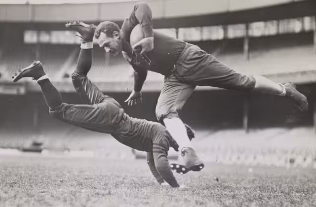 Football players Red Grange and Joe Zeller during practice [Grange & Zeller tackle]. Photo by Alan Fisher, 1935. From the New York World-Telegram and Sun Collection.