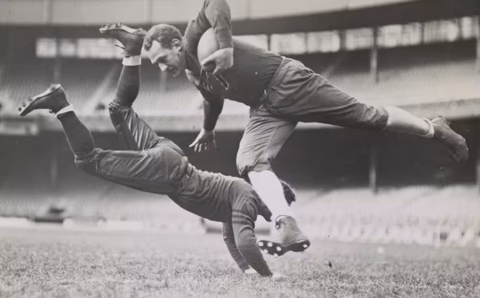 Football players Red Grange and Joe Zeller during practice [Grange & Zeller tackle]. Photo by Alan Fisher, 1935. From the New York World-Telegram and Sun Collection.
