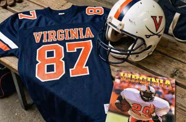 Gemini AI-created image of a 1988-era University of Virginia American football jersey 87 jersey, without a name on it, and a matching period-correct helmet, the program cover appropriate to the era and team.